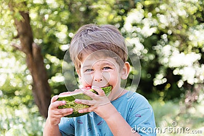 Boy eats watermelon outdoors Stock Photo