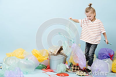 Boy eco activist sorts rubbish on blue background Stock Photo