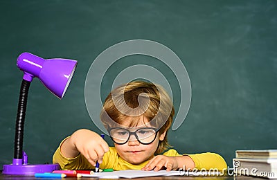 Boy from elementary school at the school yard. Cheerful smiling child at the blackboard. Science education concept. Stock Photo