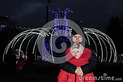 A boy embraces a girl on the background of a new year`s fountain Stock Photo