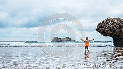 Boy enjoy with fresh wind on the ocean surf line after rain Stock Photo