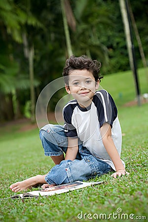 Boy enjoying his reading book in outdoor park Stock Photo