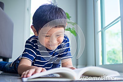 Boy enjoys reading. Smile and relax in the living room, enjoying the funny stories in the textbook Stock Photo