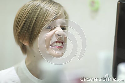 A boy examines cleaned teeth in front of a mirror Stock Photo