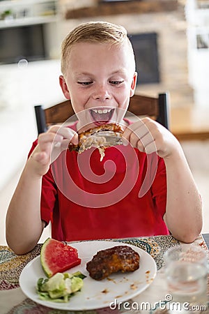 Boy excited about eating a delicious plate of Barbecue ribs Stock Photo