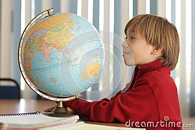 Boy looking a globe in geography class Stock Photo