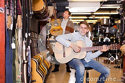 Boy and father choosing acoustic guitar Stock Photo