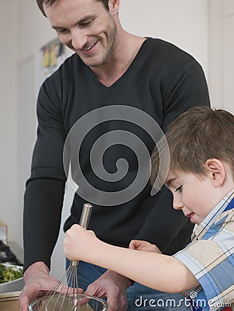 Boy And Father Cooking Food In Kitchen Stock Photo