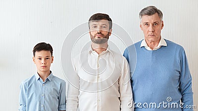 Boy, Father And Grandfather Standing Against White Wall Indoor, Panorama Stock Photo