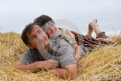 The boy and father on hay Stock Photo