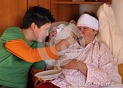 The boy feeds the sick woman Stock Photo