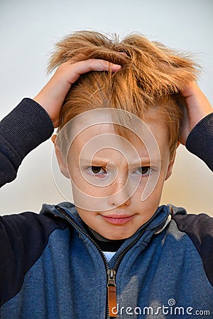 Boy feels misunderstood and pulls his hair Stock Photo