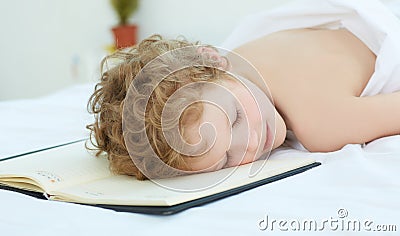 Boy fell asleep on the entries in the notebook. Healthy sleep concept Stock Photo
