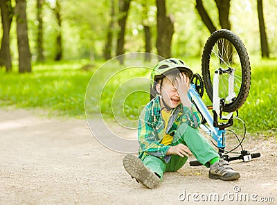Boy fell from the bike in a park Stock Photo