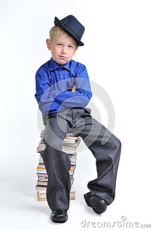 Boy with folded hands on the heap of books Stock Photo