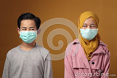 Boy and girl, brother and sister wearing medical mask to prevent covid coronavirus infection, social distancing Stock Photo