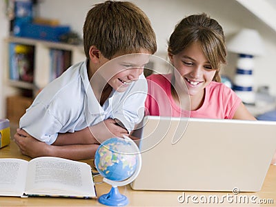 Boy And Girl Doing Their Homework On A Laptop Stock Photo