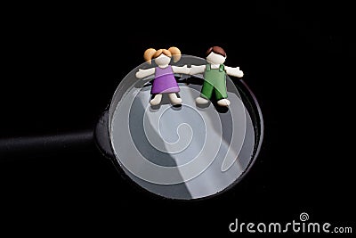 Boy and girl figurine on a magnifying glass Stock Photo