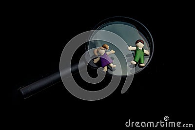 Boy and girl figurine on a magnifying glass Stock Photo