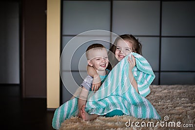 Boy and girl hiding under the blanket Stock Photo