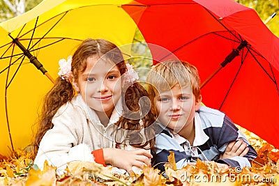 Boy and girl lying on yellow leafage Stock Photo