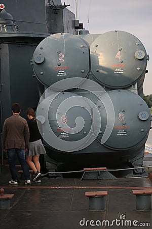 A boy and a girl pass by four-way launcher of anti-ship cruise missiles P-270 Moskit Editorial Stock Photo