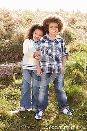 Boy And Girl Playing In Field Together Stock Photo