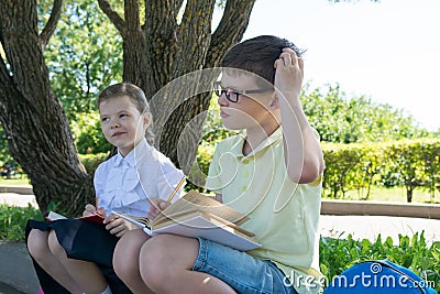 The boy and the girl pondered the solution of the task on the street Stock Photo