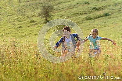 Boy and girl running on field Stock Photo