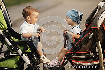 Boy and girl in baby carriages Stock Photo