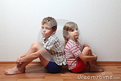 Boy and girl sitting back to back Stock Photo