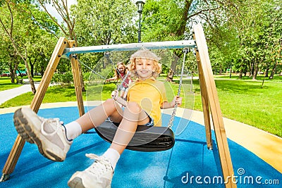 Boy and girl swing in opposite directions Stock Photo