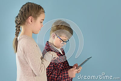 Boy and girl with tablet. Girl shows the boy how to operate the tablet. Back to school Stock Photo