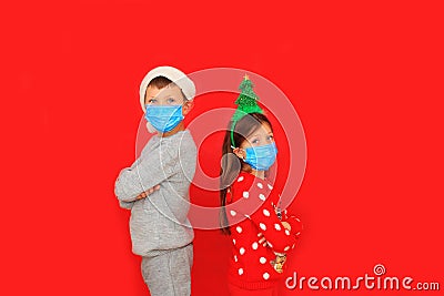 A boy and a girl wearing respiratory masks keep their distance Stock Photo