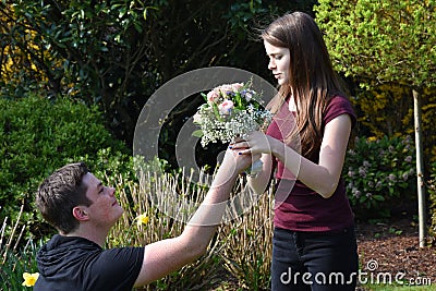 Boy gives flowers to his girlfriend Stock Photo