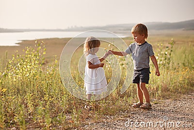 Boy giving bouquet of spring flowers to happy girl Stock Photo