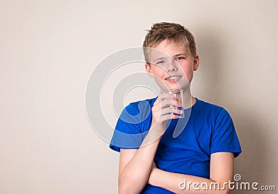 Boy with glass of water with copyspace. Smiling teenage Stock Photo