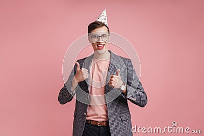 Boy in glasses in birthday cap showing thumbs up Stock Photo