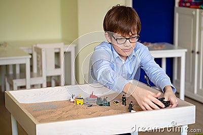 Boy glasses is sand therapy on table with light Stock Photo