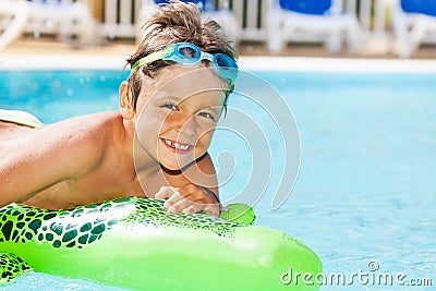 Boy in goggles swimming with inflatable toy Stock Photo