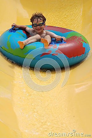 Boy going down slide in waterpark Stock Photo