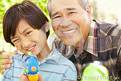 Boy and grandfather with water pistols Stock Photo