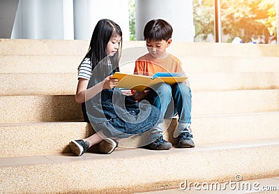 Boy and gril are reading book together,warm light tone Stock Photo