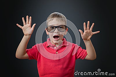 A boy with hands raised plays a monster or reacts to a scary moment in a movie Stock Photo