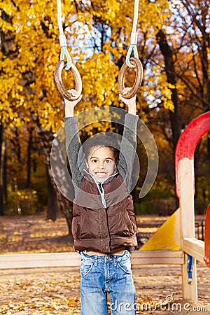 Boy hanging on the rings Stock Photo