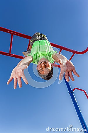 Boy hangs upside down while playing. Stock Photo