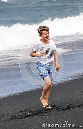 Boy has fun at the black volcanic beach Stock Photo