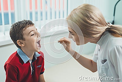 Boy has strep throat. Children`s ENT doctor examines boy`s throat. Children`s diseases, medical examination. medical test in Stock Photo
