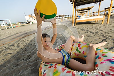 Boy has volleyball ball on the beach Stock Photo