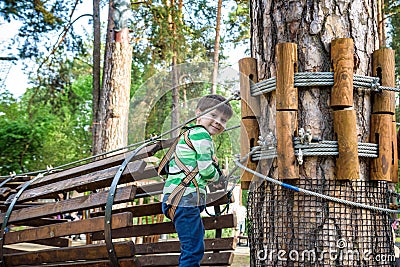 Boy having fun at adventure park. toddler climbing in a rope playground structure. toddler climbing in a rope playground structure Stock Photo